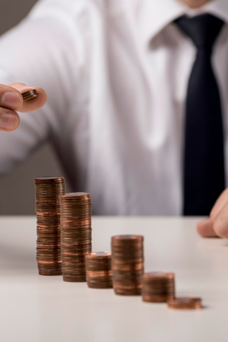 businessman-adding-coin-stack businessman-adding-coin-stack